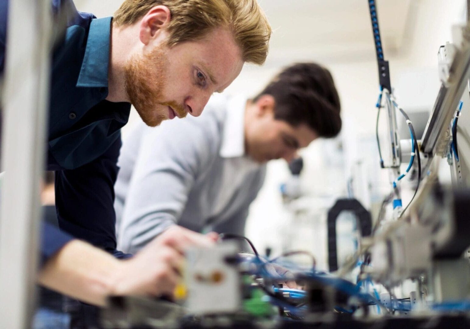 Two men working on electronics in a lab.